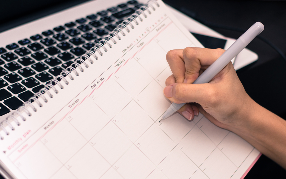 Hand,Of,Women,Planning,On,Calender,At,Her,Office